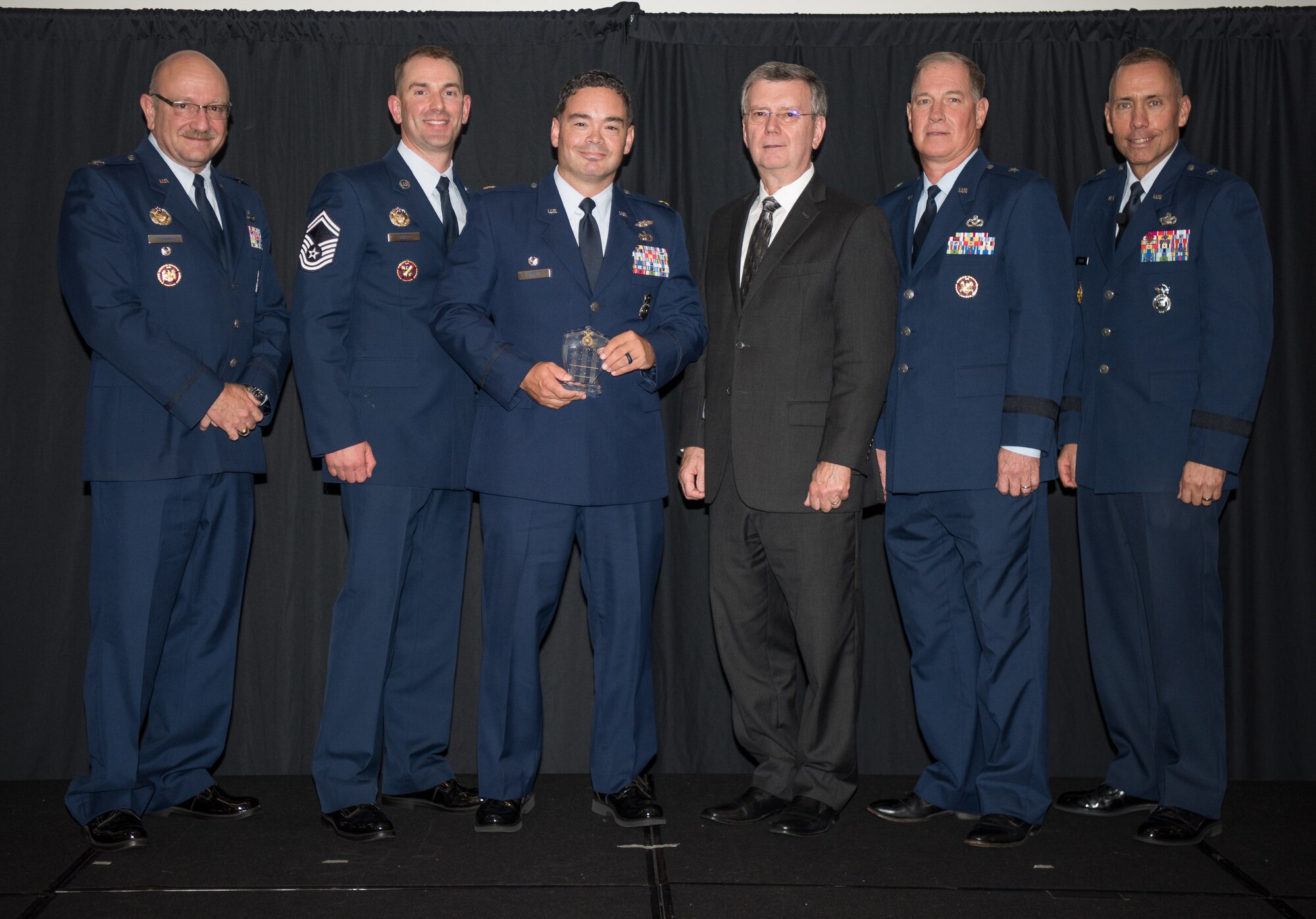 Maj. Shawn Stroup, 101st Security Forces Squadron (101st SFS), Bangor International Airport, Maine, receives the Air National Guard Outstanding Air Reserve Component Security Forces Senior Noncommissioned Officer of 2017 Award on behalf of the actual recepient, Master Sgt. Walter Dow, 101st SFS, at the 2018 Air National Guard Security Forces Squadron Dinner and Awards Banquet at the National Center for Employee Development Conference Center in Norman, Oklahoma, Sept. 12, 2018. Every year, leadership from all of the Air National Guard security forces squadrons meet in one place to discuss past, current and upcoming topics that impact the career field, as well as recognize outstanding security forces Airmen. (U.S. Air National Guard Photo by Staff Sgt. Kasey M. Phipps)