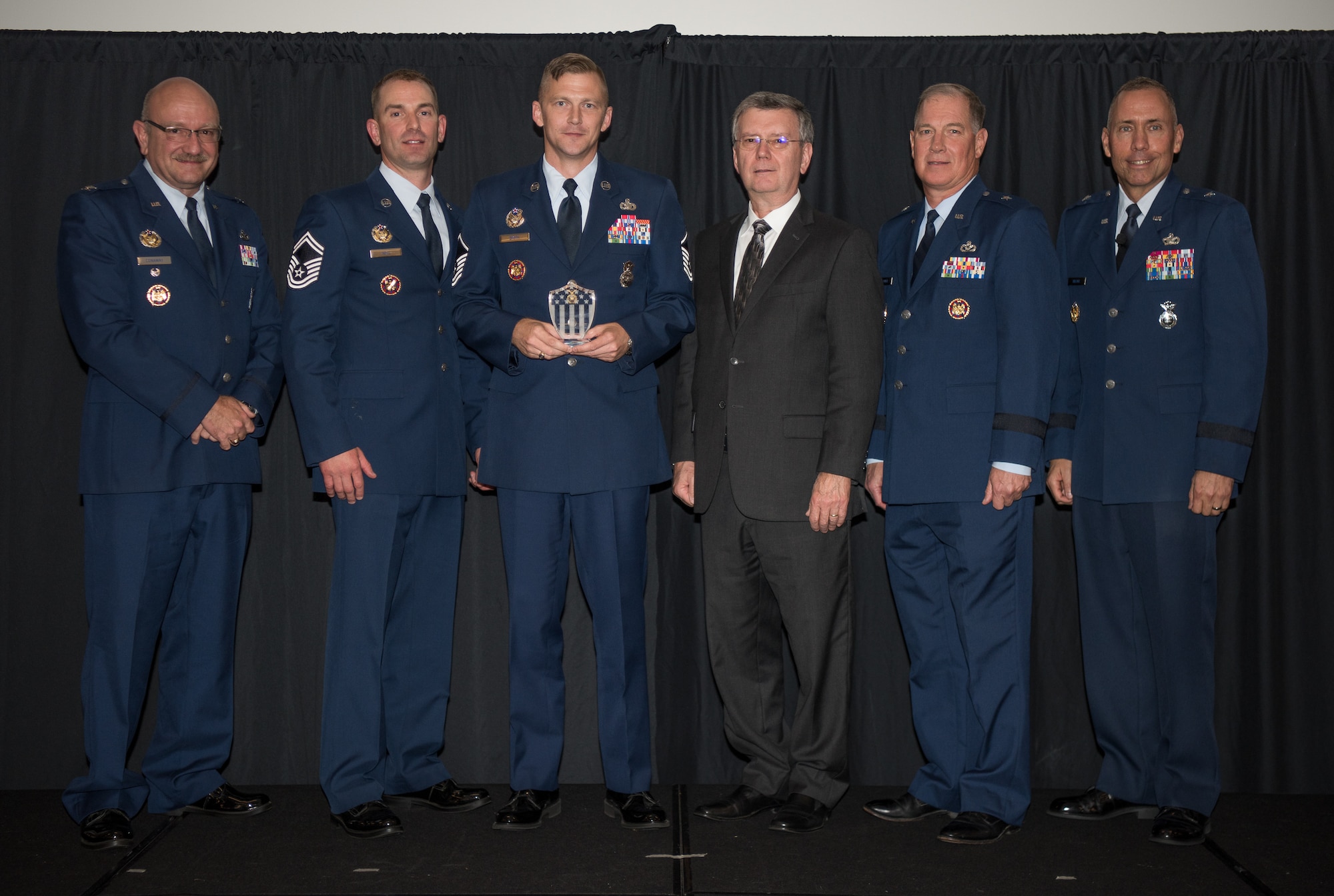 Master Sgt. Olen Smith III, National Guard Bureau/Air National Guard Security Forces Division, Joint Base Andrews, Maryland, receives the Air National Guard Higher Headquarters Staff Noncommissioned Officer of 2017 Award at the 2018 Air National Guard Security Forces Squadron Dinner and Awards Banquet at the National Center for Employee Development Conference Center in Norman, Oklahoma, Sept. 12, 2018. Every year, leadership from all of the Air National Guard security forces squadrons meet in one place to discuss past, current and upcoming topics that impact the career field, as well as recognize outstanding security forces Airmen. (U.S. Air National Guard Photo by Staff Sgt. Kasey M. Phipps)