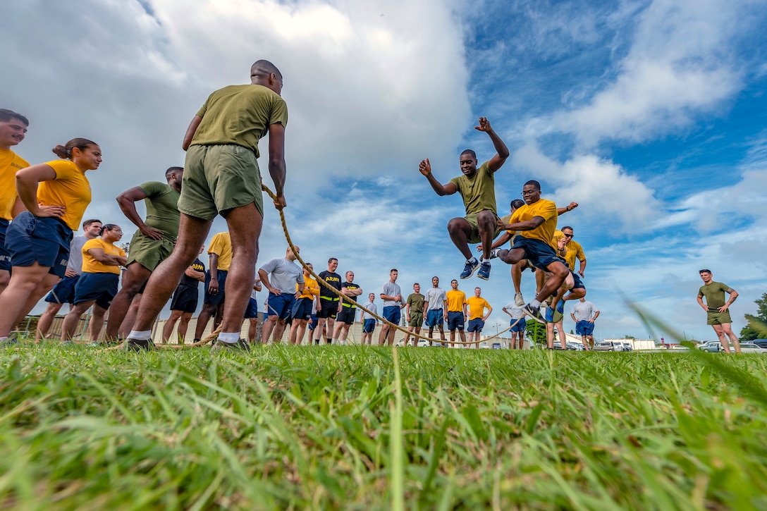 Service members jump rope while others watch.