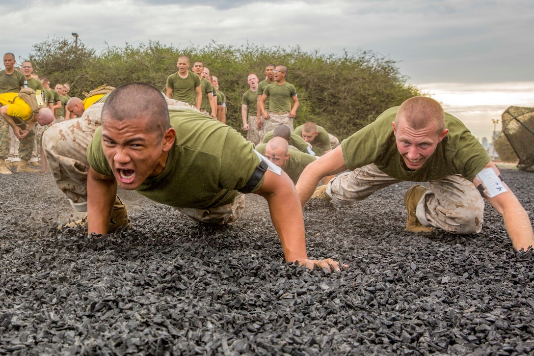 Marines crawl over gravel.