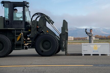 U.S. Air Force Staff Sgt. Jonathan Armstrong, a documented cargo noncommissioned officer in charge with the 374th Logistics Readiness Squadron, Yokota Air Base, Japan, gives instructions to Senior Airman Thomas Scholtz, a ground transportation vehicle operator with the 35th Logistics Readiness Squadron, Misawa Air Base, Japan, as he operates a 10k all-terrain forklift, during Red Flag-Alaska 18-4 at Joint Base Elmendorf-Richardson, Alaska, Oct. 1, 2018. Red Flag-Alaska is a Pacific Air Forces-directed field training exercise for U.S. and international forces flown under simulated air combat conditions. The exercises are focused on improving the combat readiness of U.S. and international forces and providing training for units preparing for air expeditionary force taskings.