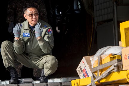 Republic of Korea Air Force Chief Master Sgt. Wooseop Lim, loadmaster assigned to the 15th Special Missions Wing, signals to a 10k all-terrain forklift operator during Red Flag-Alaska 18-4 at Joint Base Elmendorf-Richardson, Alaska, Oct. 1, 2018. Red Flag-Alaska is a Pacific Air Forces-directed field training exercise for U.S. and international forces flown under simulated air combat conditions. The exercises are focused on improving the combat readiness of U.S. and international forces and providing training for units preparing for air expeditionary force taskings.