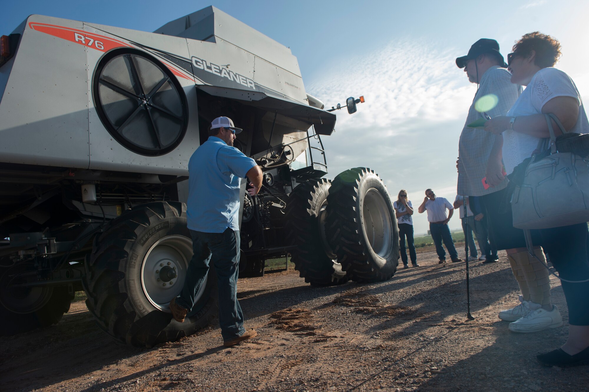 A man talking to people in front of a tractor