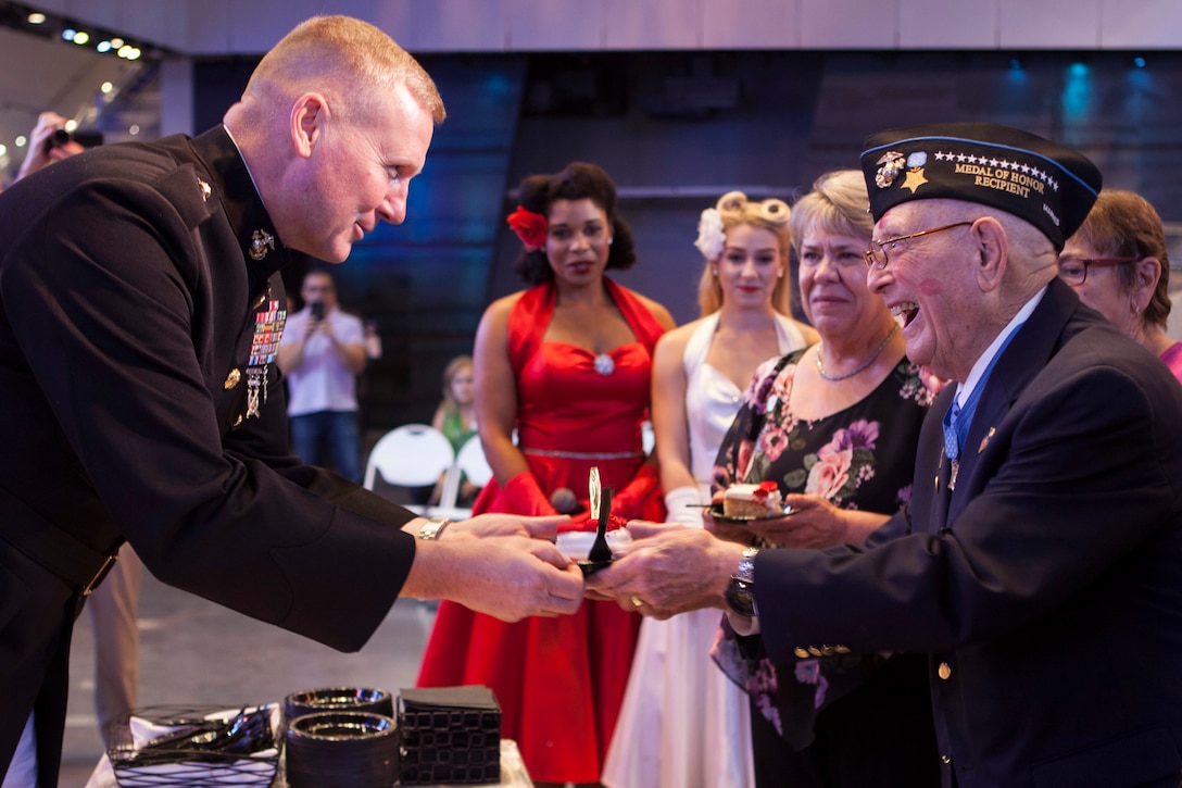 Brig. Gen. Bradley S. James, commanding general of 4th Marine Aircraft Wing, presents a slice of cake to retired Chief Warrant Officer 4 Hershel “Woody” Williams, the last surviving Medal of Honor recipient from the Battle of Iwo Jima, during Williams’ 95th birthday party at the National World War II Museum, Oct. 2, 2018. Williams enlisted in the Marine Corps Reserve in 1943 and served in the Battle of Iwo Jima with 21st Marines, 3rd Marine Division in 1945. (U.S. Marine Corps photo by Lance Cpl Tessa D. Watts)