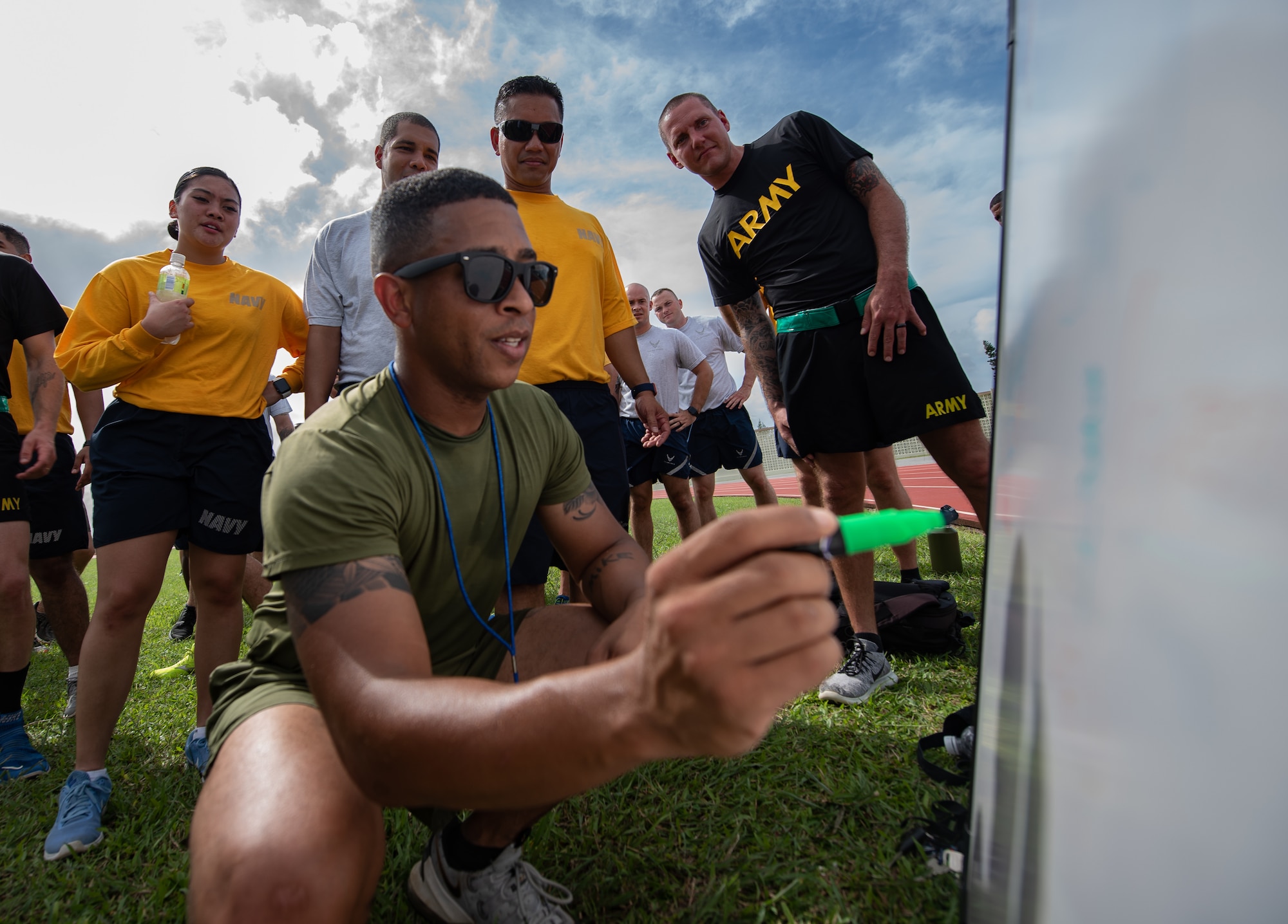 U.S. Marine Corps 1st Sgt. Michael Collins, Okinawa Joint Experience instructor, updates each team’s score during the Okinawa Joint Fitness Challenge Sept. 26, 2018, at Kadena Air Base, Japan. After calculating points from the push-up challenge, combat fitness challenge and tug-of-war, the Green Team was determined the winner of the OJFC. (U.S. Air Force photo by Staff Sgt. Micaiah Anthony)