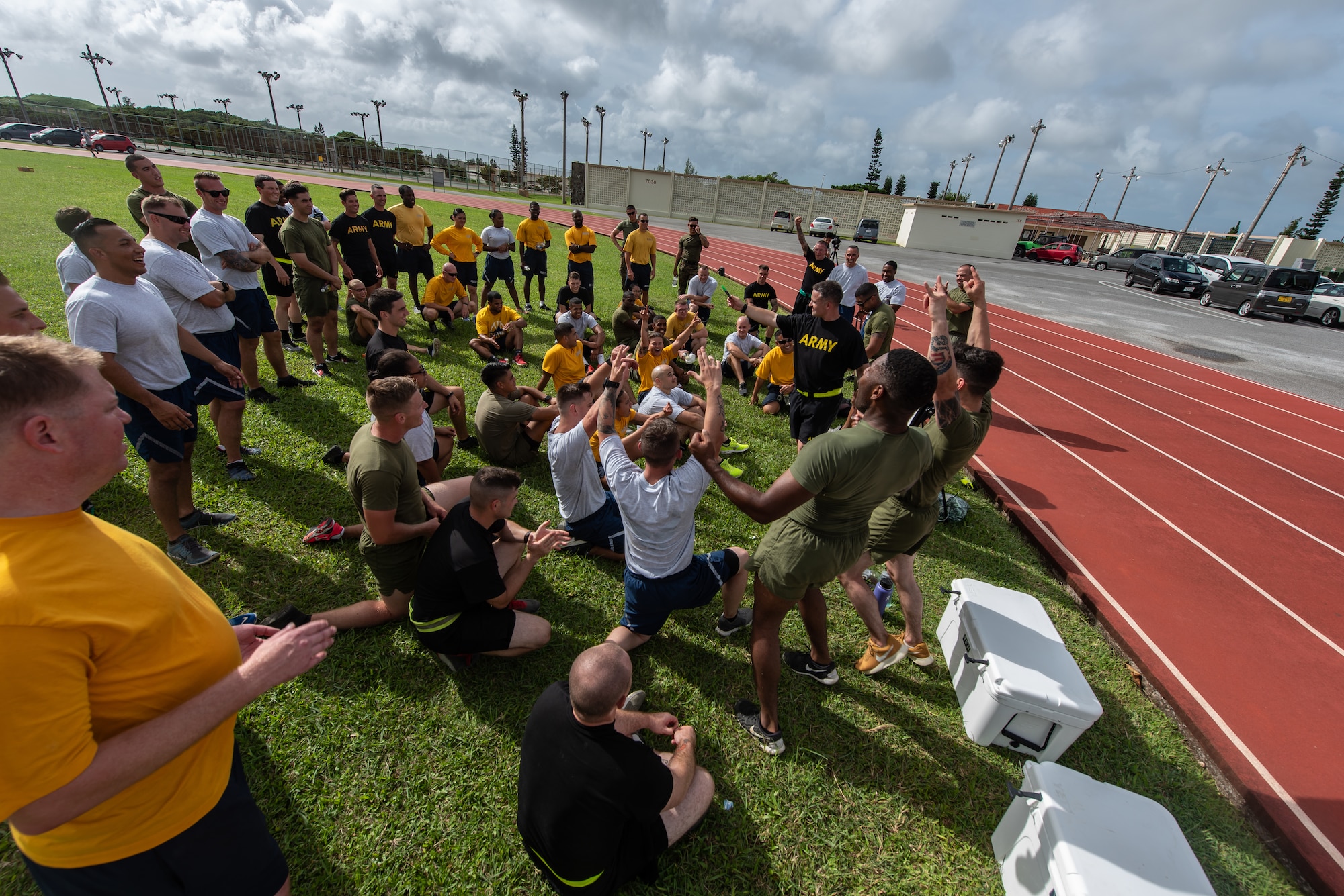 Members of the Green Team celebrate after being announced the winner of the Okinawa Joint Fitness Challenge Sept. 26, 2018, at Kadena Air Base, Japan. The OJFC was designed to mimic obstacles and challenges faced in the battlefield such as sprinting, running ammunition cans, transporting wounded personnel to safety and tossing simulated grenades. Each team competed for the best time, however the final challenge brought all four teams together. (U.S. Air Force photo by Staff Sgt. Micaiah Anthony)