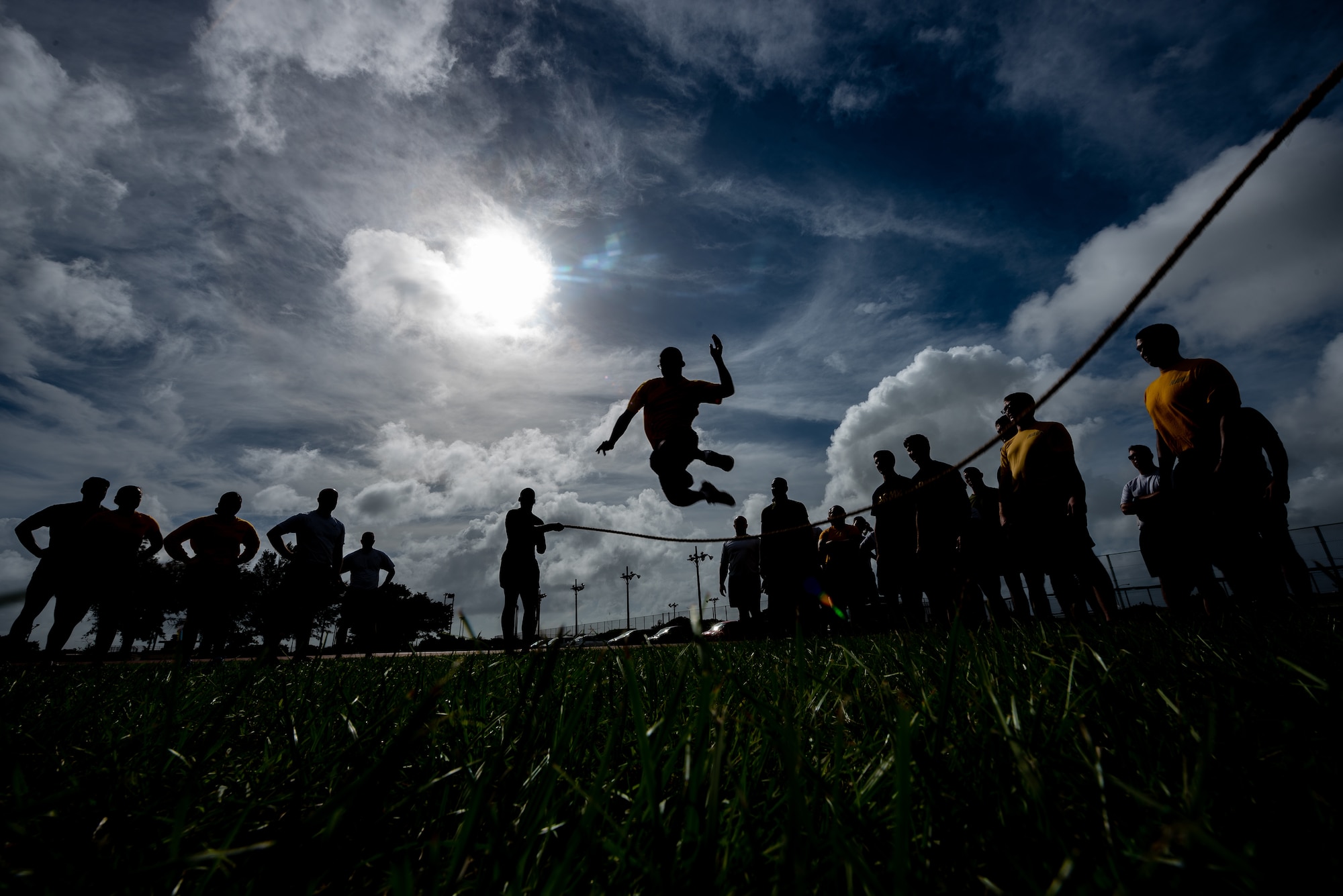 U.S. Soldiers, Sailors, Marines and Airmen take turns jumping over a rope during the Okinawa Joint Fitness Challenge Sept. 26, 2018, at Kadena Air Base, Japan. The jump rope challenge required all 48 students to jump over the rope while it was in motion. If the rope touched a student while they were jumping over, or if the rope stopped, the students would have to start over again. (U.S. Air Force photo by Staff Sgt. Micaiah Anthony)