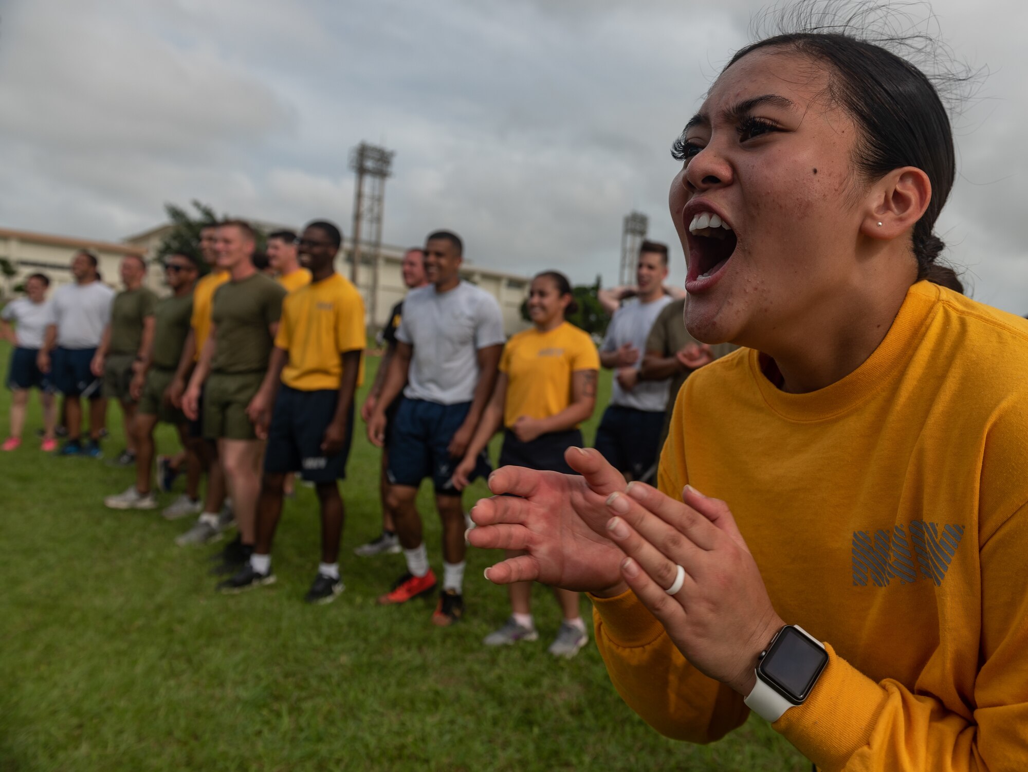 U.S. Navy Petty Officer 3rd Class Roey-Rose Panganiban, Okinawa Joint Experience Gold Team student, motivates fellow service members as they take turns jumping over a rope during the Okinawa Joint Fitness Challenge Sept. 26, 2018, at Kadena Air Base, Japan. The jump rope challenge required all 48 students to jump over the rope while it was in motion. If the rope touched a student while they were jumping over, or if the rope stopped, the students would have to start over again. (U.S. Air Force photo by Staff Sgt. Micaiah Anthony)