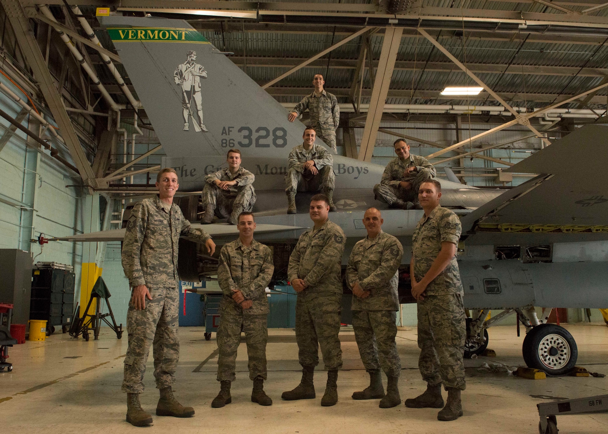 U.S. Air Force aircraft maintainers assigned to the 158th Fighter Wing, pose in front of the tail of an F-16 during a phase inspection at the Vermont Air National Guard Base, August 1, 2018. Aircraft 328 was the last F-16 to undergo a phase inspection as the unit transitions to the F-35 Lightning II in fall of 2019. (U.S. Air National Guard photo by 2nd. Lt. Chelsea Clark)