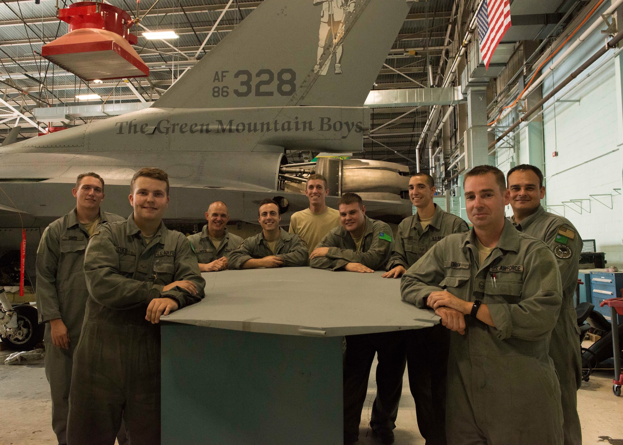 U.S. Air Force aircraft maintainers assigned to the 158th Fighter Wing, pose in front of the tail of an F-16 during a phase inspection at the Vermont Air National Guard Base, August 1, 2018. Aircraft 328 was the last F-16 to undergo a phase inspection as the unit transitions to the F-35 Lightning II in fall of 2019. (U.S. Air National Guard photo by 2nd. Lt. Chelsea Clark)