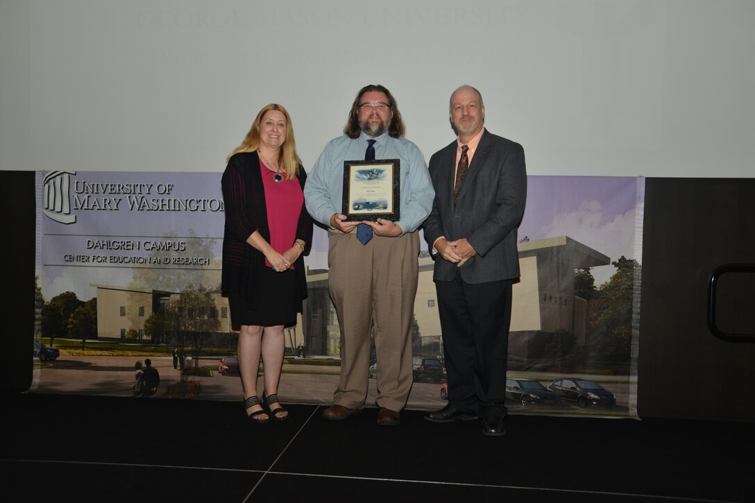 IMAGE: DAHLGREN, Va. (Sept. 21, 2018) – John Rigsby receives his certificate of achievement from Naval Surface Warfare Center Dahlgren Division (NSWCDD) Acting Chief of Staff Terri Gray and Acting Deputy Technical Director Chris Clifford at the 2018 NSWCDD Academic Recognition Ceremony.