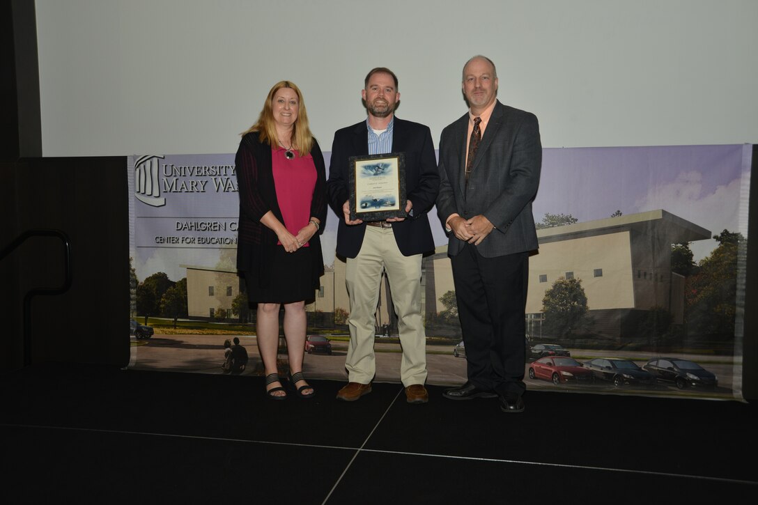 IMAGE: DAHLGREN, Va. (Sept. 21, 2018) – Joel Mejeur receives his certificate of achievement from Naval Surface Warfare Center Dahlgren Division (NSWCDD) Acting Chief of Staff Terri Gray and Acting Deputy Technical Director Chris Clifford at the 2018 NSWCDD Academic Recognition Ceremony.