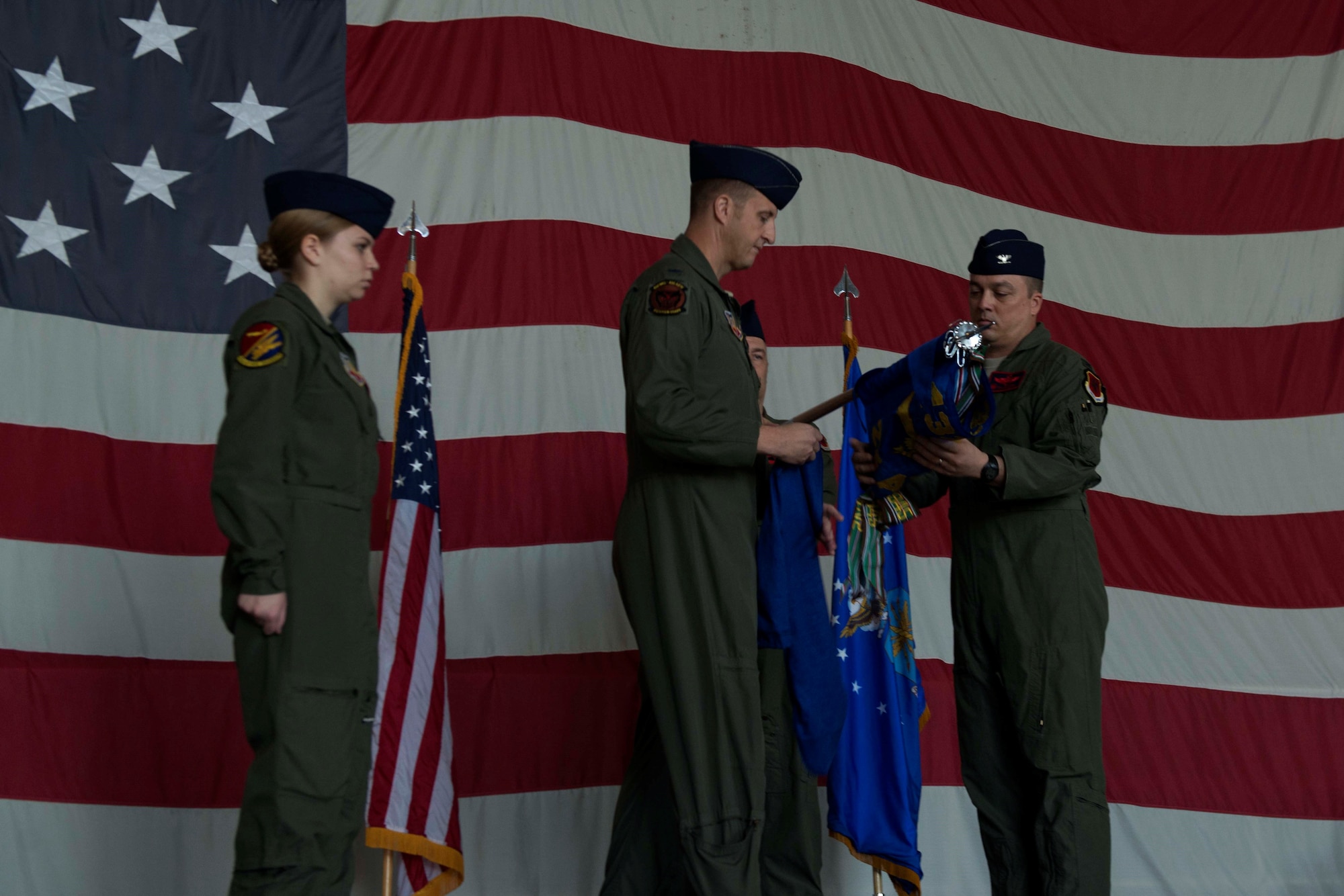 U.S. Air Force Col. Julian Cheater, 432nd Wing and 432nd Expeditionary Wing commander, center, and Col. Travis Norton, 25th Attack Group (ATKG) commander, right, unfurl the 25th ATKG guidon at Shaw Air Force Base (AFB), S.C., Oct. 2, 2018.