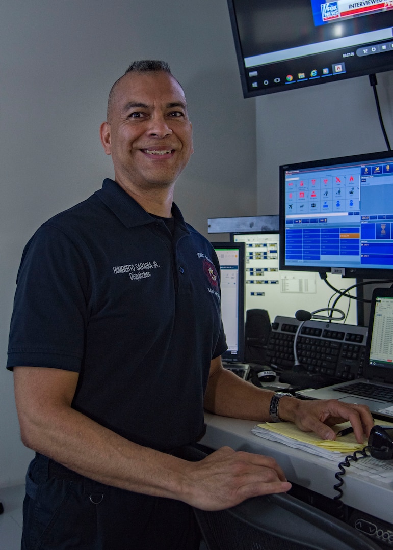 Humberto Sarabia Jr., lead dispatcher for the 502nd Civil Engineer Group/Fire Department, poses by his workstation in the dispatch center on Joint Base San Antonio-Randolph, Texas, Oct. 3, 2018. Sarabia and his crew have been described as the “fingers on the pulse” because any emergency call on base goes through them first. (U.S. Air Force photo by Airman Shelby Pruitt)