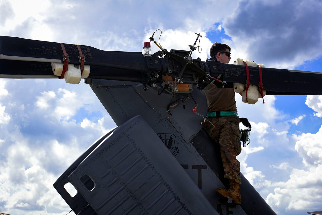 Airman 1st Class James McLaughlin, 41st Helicopter Maintenance Unit HH-60G Pave Hawk crew chief, helps navigate a helicopter into a C-5 Galaxy, prior to a deployment, Sept. 26, 2018, at Moody Air Force Base, Ga. The 41st RQS and the 41st Helicopter Maintenance Unit will provide combat search and rescue capabilities and maintenance operations in a forward deployed location. (U.S. Air Force photo by Senior Airman Greg Nash)