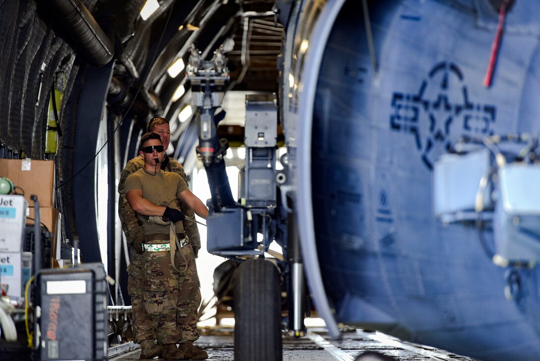Airman 1st Class Thomas Kervian, 41st Helicopter Maintenance Unit HH-60G Pave Hawk crew chief, guides a helicopter to be secured in a C-5 Galaxy prior to a deployment, Sept. 26, 2018, at Moody Air Force Base, Ga. The 41st RQS and the 41st Helicopter Maintenance Unit will provide combat search and rescue capabilities and maintenance operations in a forward deployed location. (U.S. Air Force photo by Senior Airman Greg Nash)