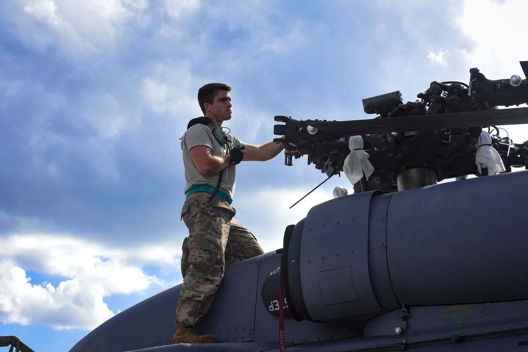 Airman 1st Class Nicholas Rodriguez, 41st Helicopter Maintenance Unit HH-60G Pave Hawk crew chief, helps guide a helicopter into a C-5 Galaxy prior to a deployment, Sept. 26, 2018, at Moody Air Force Base, Ga. The 41st RQS and the 41st Helicopter Maintenance Unit will provide combat search and rescue capabilities and maintenance operations in a forward deployed location. (U.S. Air Force photo by Senior Airman Greg Nash)