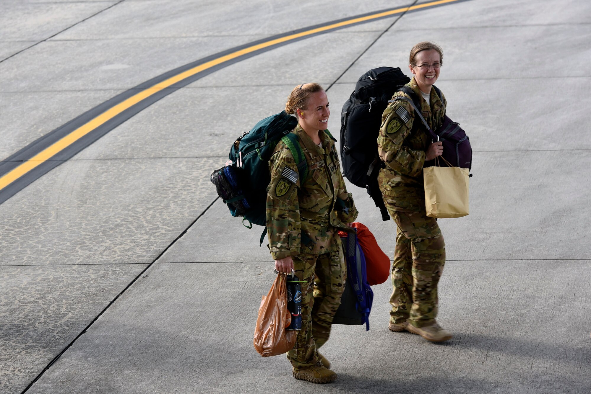 41st Rescue Squadron HH-60G Pave Hawk helicopter pilots Capt. Amanda May, left, and Capt. Chelsey Hamilton, share a laugh before boarding a C-5 Galaxy prior to a deployment, Sept. 26, 2018, at Moody Air Force Base, Ga. The 41st RQS and the 41st Helicopter Maintenance Unit will provide combat search and rescue capabilities and maintenance operations in a forward deployed location. (U.S. Air Force photo by Senior Airman Greg Nash)
