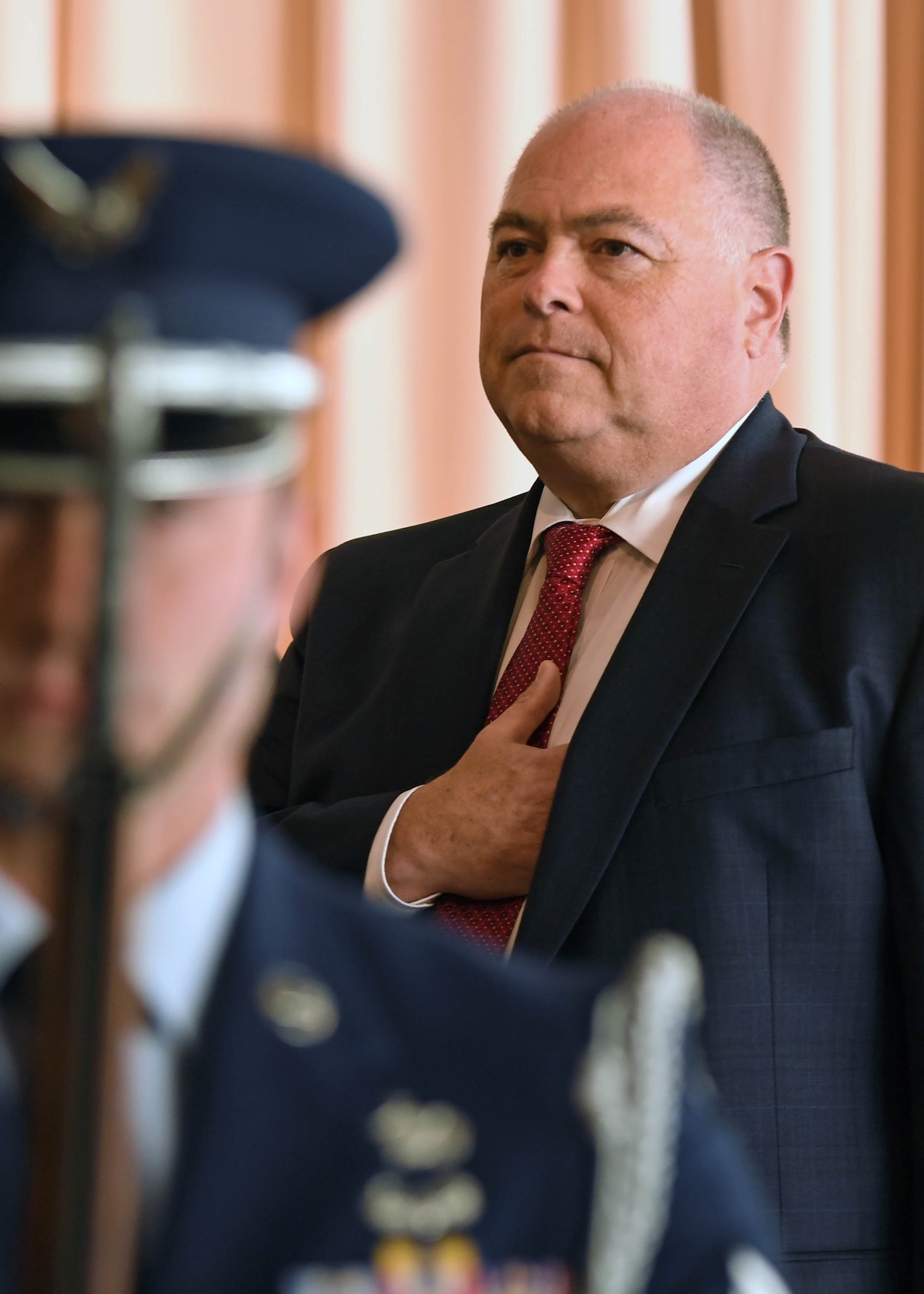 Joe Bradley listens to the national anthem behind a Patriot Honor Guard member during his own swearing-in ceremony to the Senior Executive Service, Sept. 27, 2018, at the Minuteman Commons at Hanscom Air Force Base, Mass. Bradley now leads the Cyber Resiliency Office for Weapons Systems and is Air Force Life Cycle Management Center-Hanscom’s associate director of Engineering and Technical Management. (U.S. Air Force photo by Todd Maki)