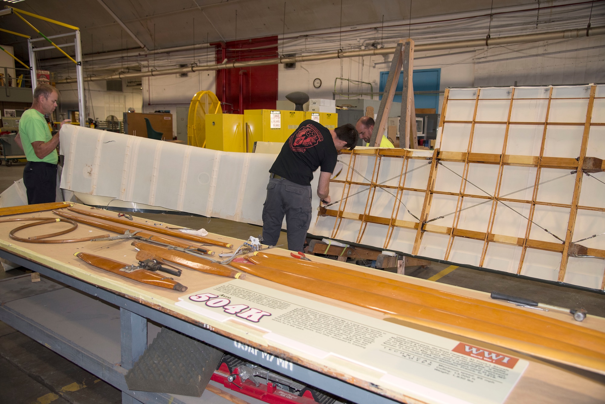 DAYTON, Ohio -- Museum restoration specialists Brian Lindamood(L) and Casey Simmons(R) remove wing fabric on the Avro 504K which was originally built in 1966 by the Royal Canadian Air Force's Aircraft Maintenance & Development Unit. Preserving the Air Force's proud legacy, the Restoration Division restores aircraft and aerospace vehicles to historically accurate and visually striking levels. (U.S. Air Force photo by Ken LaRock)