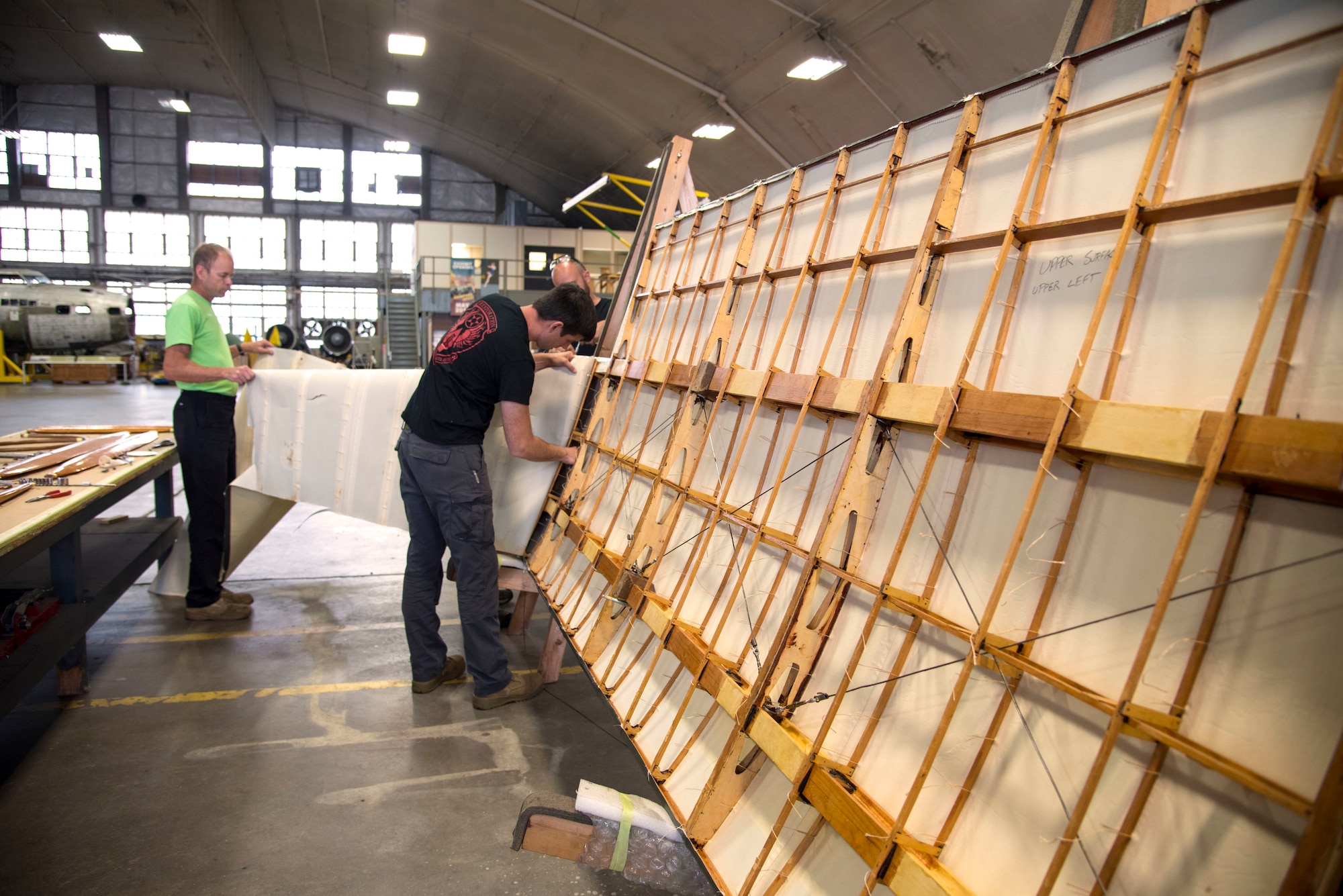 DAYTON, Ohio -- Museum restoration specialists Brian Lindamood(L) and Casey Simmons(R) remove wing fabric on the Avro 504K which was originally built in 1966 by the Royal Canadian Air Force's Aircraft Maintenance & Development Unit. Preserving the Air Force's proud legacy, the Restoration Division restores aircraft and aerospace vehicles to historically accurate and visually striking levels. (U.S. Air Force photo by Ken LaRock)