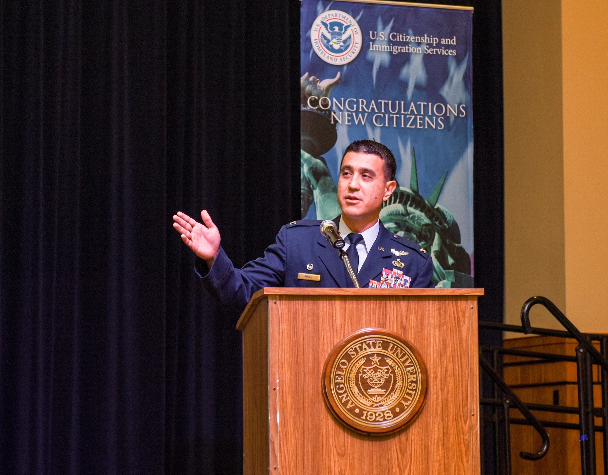 U.S. Air Force Col. Ricky Mills, 17th Training Wing commander, speaks during the naturalization ceremony held on Sept. 25, 2018 at the CJ Davidson Center on Angelo State University, San Angelo, Texas. Mills shared stories about how his mother was naturalized in 1974 in San Francisco when he was only two-years-old. (U.S. Air Force photo by Aryn Lockhart/Released).