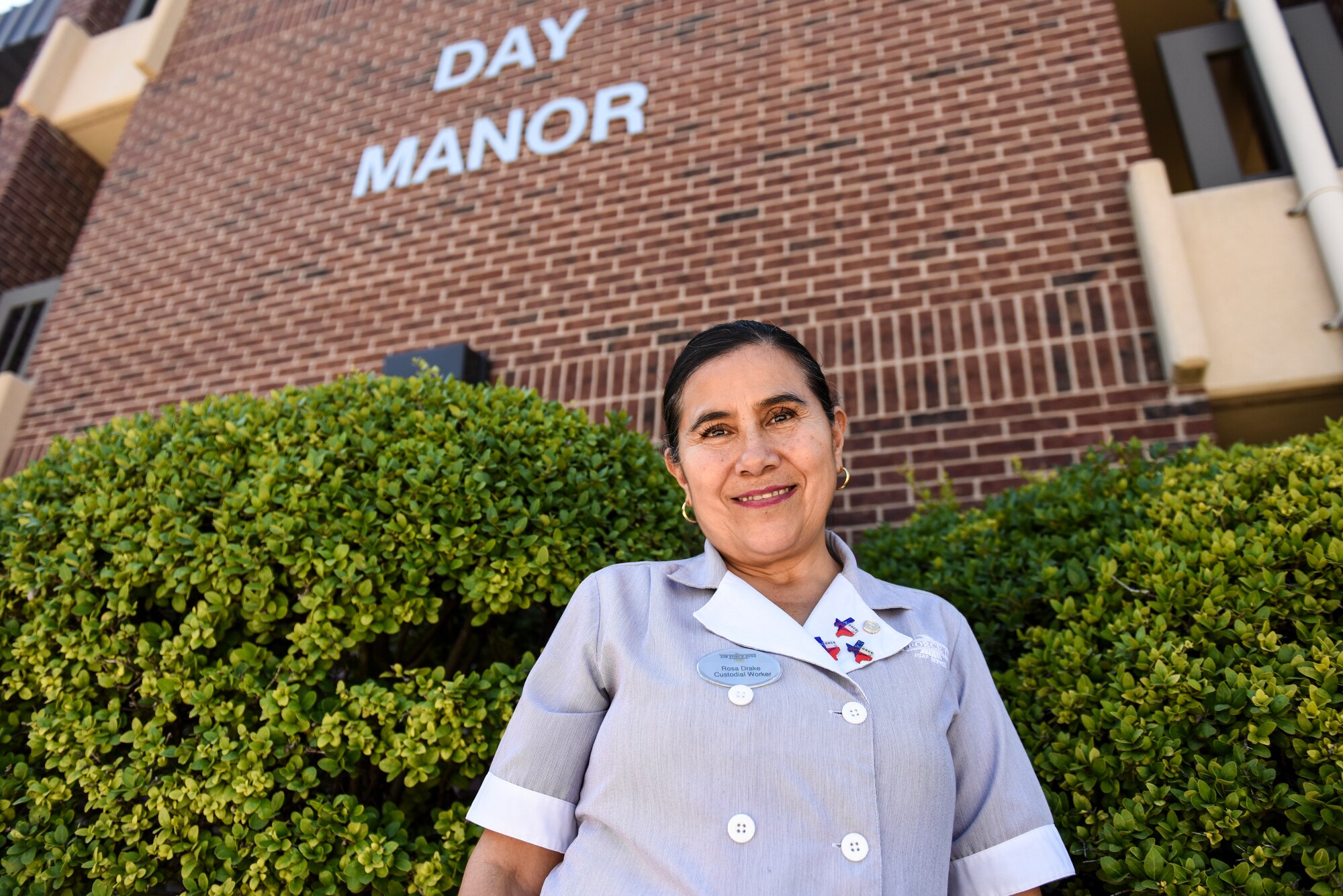 Angelo Inn housekeeper, Rosa Drake, stands before Day Manor where she works on Goodfellow Air Force Base, Texas, Sept. 24, 2018.  Drake has worked for Air Force lodging for five years. (U.S. Air Force photo by Aryn Lockhart/Released)