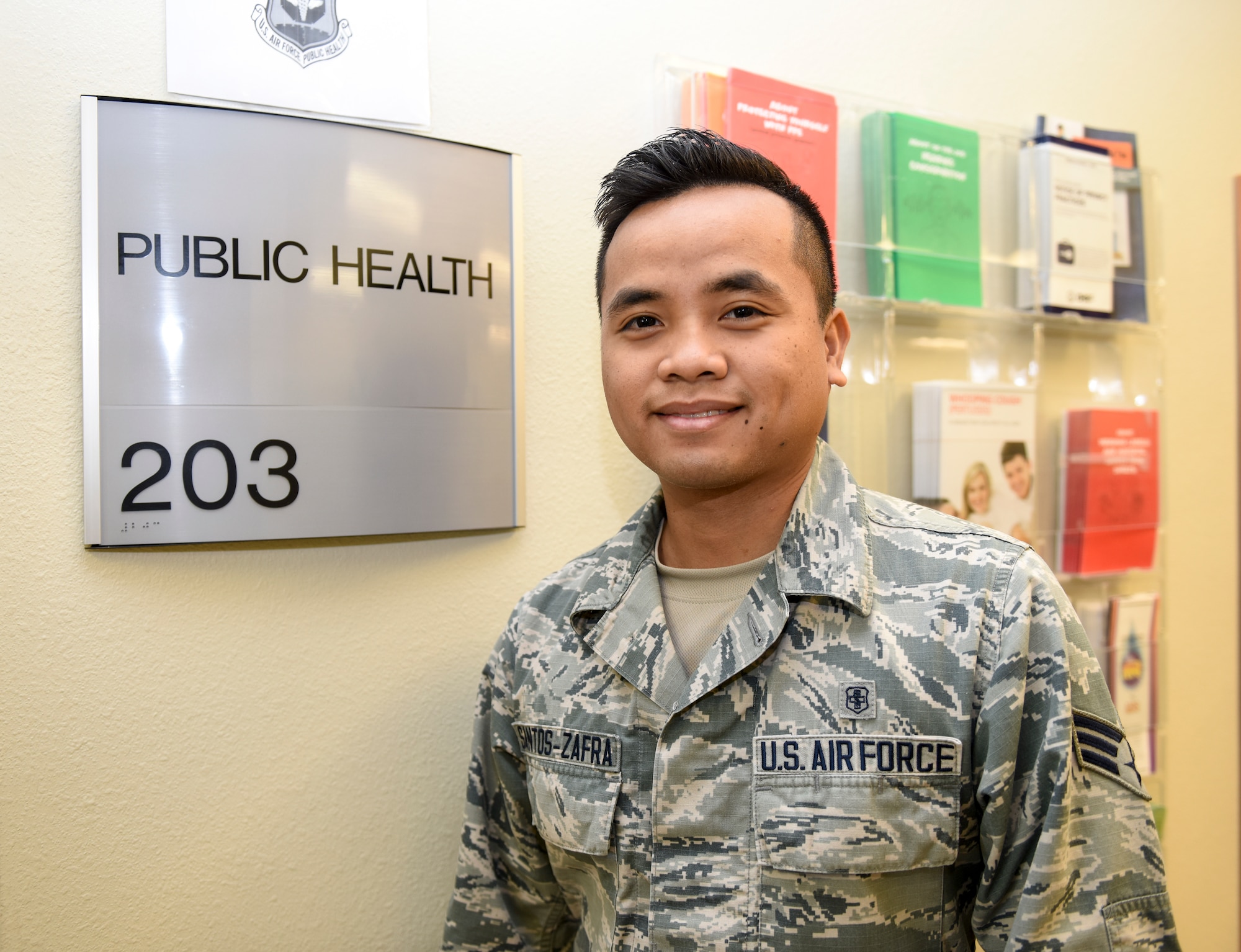 U.S. Air Force Senior Airman John Santos Zafra, 17th Medical Operations Squadron public health technician stands next to his office at the Ross Clinic on Goodfellow Air Force Base, Texas, Sept. 24, 2018. Zafra has been living in the states since he was 13- years-old and used the assistance of the Air Force to become a U.S. citizen.  (U.S. Air Force photo by Aryn Lockhart/Released)