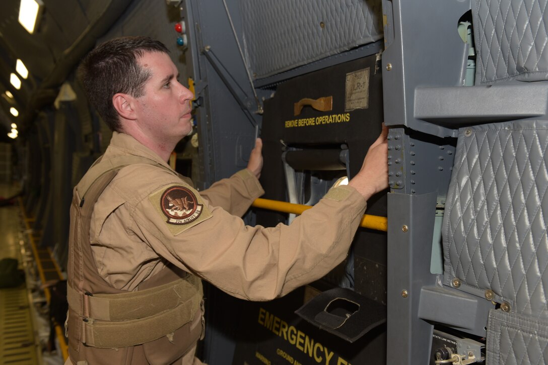 Tech. Sgt. David Bass, 22nd Airlift Squadron C-5M Super Galaxy loadmaster, affixes armor to the inside of one of the troop doors of a C-5 at Travis Air Force Base, Calif., Sept. 12. The armor is required to ensure air crew safety while the aircraft fly’s through hostile environments. (U.S. Air Force photo by Tech. Sgt. James Hodgman)