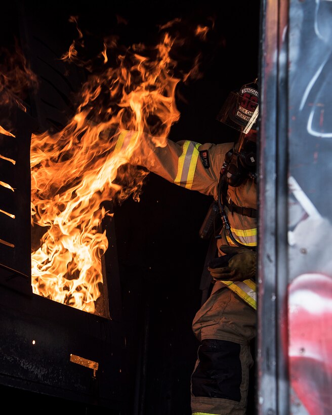 Sigfried Mertineit, 52nd Civil Engineer Squadron crew chief, conducts live-fire structural burn training at Spangdahlem Air Base, Germany, Oct. 4, 2018. The training simulated a real building fire and was the first event to kick off Fire Prevention Week. (U.S. Air Force photo by Airman 1st Class Valerie Seelye)