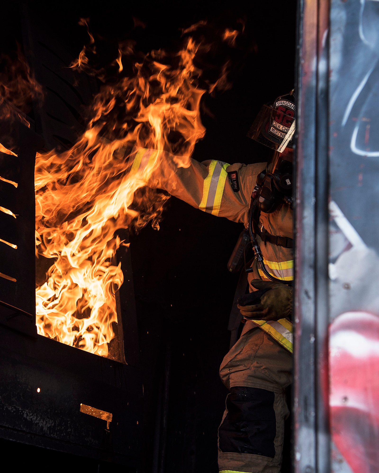 Sigfried Mertineit, 52nd Civil Engineer Squadron crew chief, conducts live-fire structural burn training at Spangdahlem Air Base, Germany, Oct. 4, 2018. The training simulated a real building fire and was the first event to kick off Fire Prevention Week. (U.S. Air Force photo by Airman 1st Class Valerie Seelye)