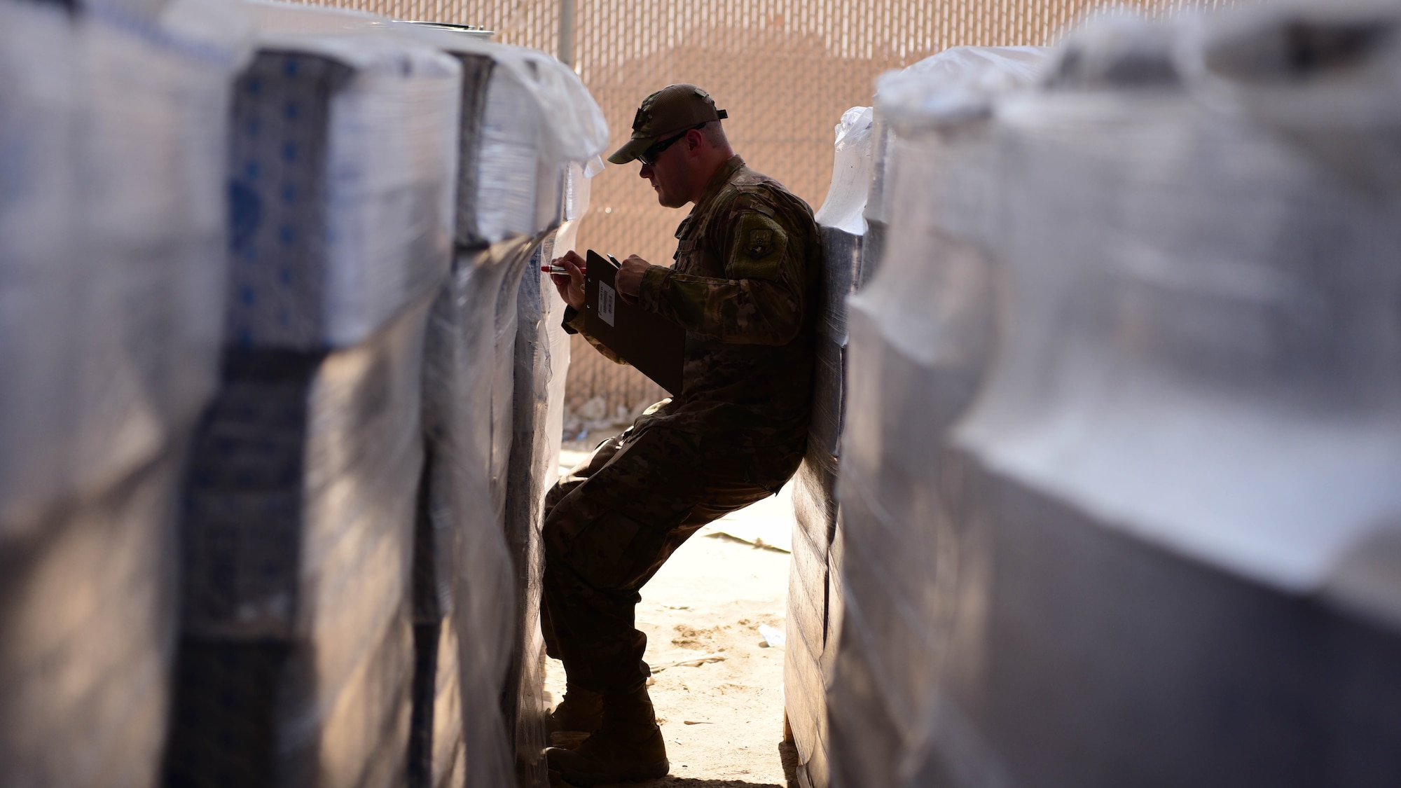 Senior Airman Adam Sanders, 386th Air Expeditionary Medical Group environmental program manager, inspects a case of water Oct. 3, 2018, at an undisclosed location in Southwest Asia. On any given week, Sanders and the bioenvironmental team inspects thousands of bottles of water for bacteria or contaminants. (U.S. Air Force photo by Staff Sgt. Christopher Stoltz)