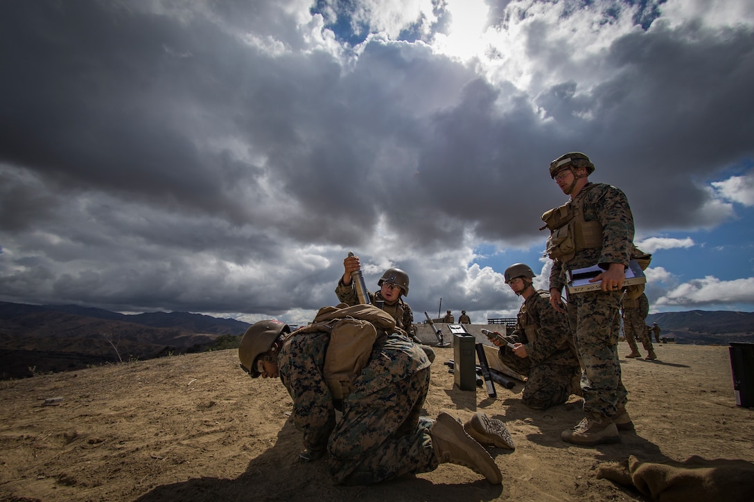 U.S. Marines with Weapons Platoon, A Company, Infantry Training Battalion, School of Infantry-West, prepare to fire a 60mm mortar round during the Basic Mortarman Course at Range Mortar Position 6, Marine Corps Base Camp Pendleton, California, Oct. 4, 2018. The Marines were evaluated on the use and employment of the 60mm M224 mortar system. They must successfully qualify on the system before moving on to the 81mm M252 mortar system.
