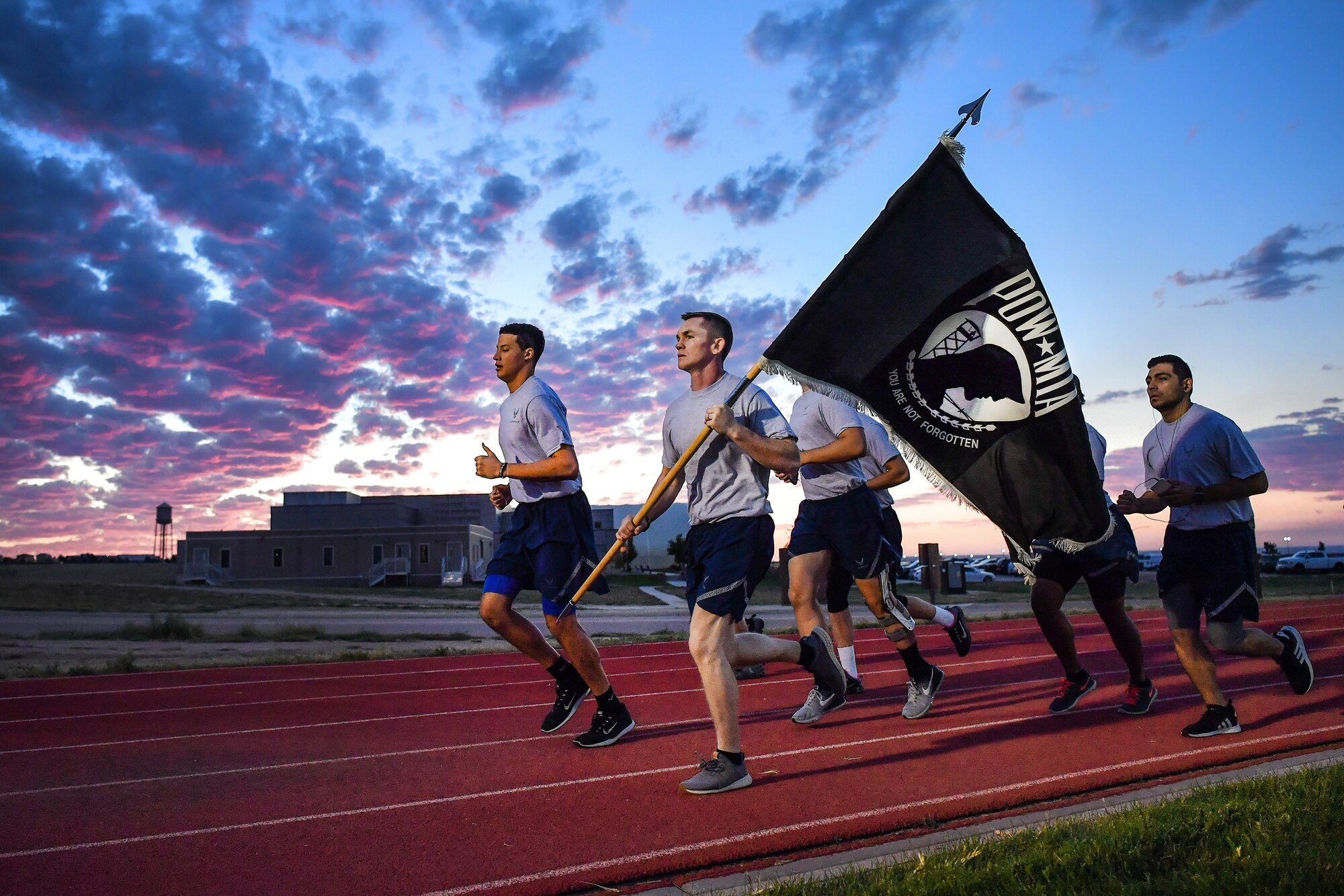 Airmen run with the POW/MIA flag in the early morning hours during a 24-hour run at Schriever Air Force Base, Colo., Sept. 19, 2018. Airmen from various squadrons continuously ran with the POW/MIA flag in 30 minute intervals, with more than 70 participants carrying the flag for a total of 120 miles. (U.S. Air Force photo by Kathryn Calvert)