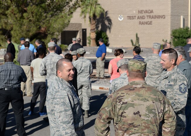 Employees at the Nevada Testing and Training Range building stand outside during a fire drill at Nellis AFB, Nev., Oct 4, 2018. The NTTR is the largest contiguous air and ground space available covering over 2.9 million acres of land. (U.S. Air Force photo by Airman 1st Class Bryan T. Guthrie)