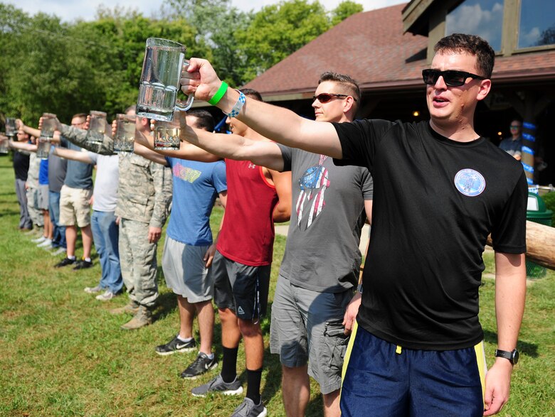 Members of the National Air and Space Intelligence Center compete in a Stein Raise competition during the National Air and Space Intelligence Center’s Oktoberfest on Wright-Patterson Air Force Base, Ohio, Sept. 21, 2018. During the competition participants were challenged to see who would be the last one holding the mug of water.. (U.S. Air Force photo by Senior Airman Michael Hunsaker)