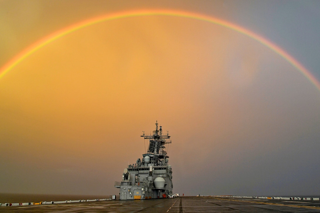 A ship is seen with a rainbow overhead