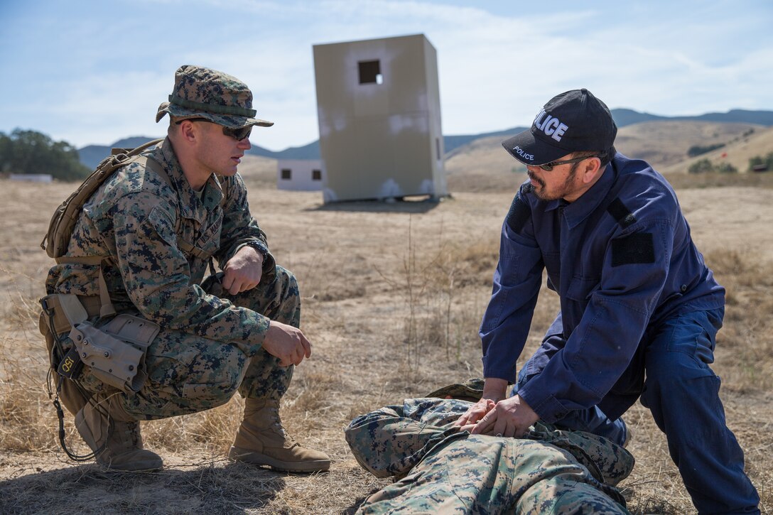 U.S. Marine Corps Cpl. Jarod A. Breeser, left, a military policeman with 1st Law Enforcement Battalion, Task Force Koa Moana (TF KM), teaches a civilian role player how to properly take down a detainee during TF KM Mission Rehearsal Exercise at Marine Corps Base Camp Pendleton, Calif., July 17, 2018. The exercise confirms TF KM is capable of cross cultural interaction, instruction, and relationship building while training alongside partner nations in order to meet Theater Security Cooperation engagement objectives. (U.S. Marine Corps photo by Staff Sgt. Gabriela Garcia)
