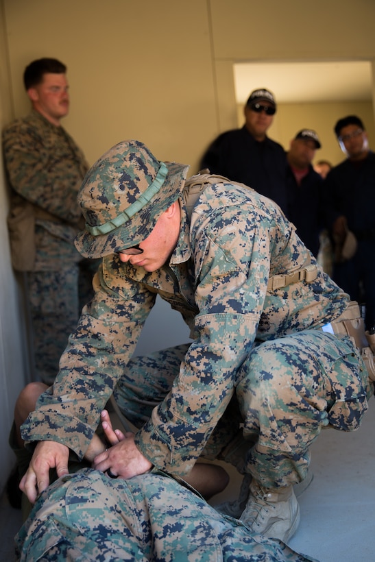 U.S. Marines Lance Cpl. Thomas E. McDonald, top, and Cpl. Stephen M. Reagin, bottom, both military policemen with 1st Law Enforcement Battalion, Task Force Koa Moana (TF KM), demonstrate law enforcement techniques to a civilian role players during TF KM Mission Rehearsal Exercise at Marine Corps Base Camp Pendleton, Calif., July 17, 2018. The exercise confirms TF KM is capable of cross cultural interaction, instruction, and relationship building while training alongside partner nations in order to meet Theater Security Cooperation engagement objectives. (U.S. Marine Corps photo by Staff Sgt. Gabriela Garcia)