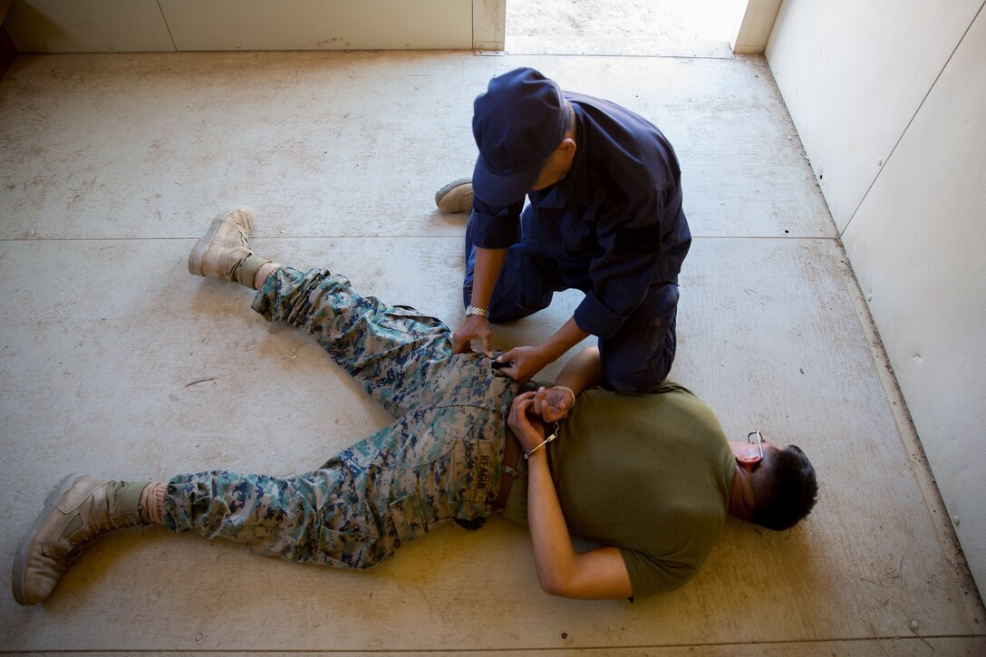 A civilian role player practices law enforcement techniques with U.S Marine Corps Cpl. Stephen M. Reagin, a military policeman with 1st Law Enforcement Battalion, Task Force Koa Moana (TF KM), during TF KM Mission Rehearsal Exercise at Marine Corps Base Camp Pendleton, Calif., July 17, 2018. The exercise confirms TF KM is capable of cross cultural interaction, instruction, and relationship building while training alongside partner nations in order to meet Theater Security Cooperation engagement objectives. (U.S. Marine Corps photo by Staff Sgt. Gabriela Garcia)