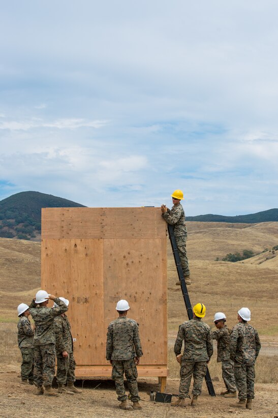 U.S. Marine Corps Cpl. Braiden M. Wadin, top, and other Marine combat engineers with Bravo Company, 7th Engineer Support Battalion, Task Force Koa Moana (TF KM), participate in the construction of a South West Asia hut during the TF KM Mission Rehearsal Exercise, at Marine Corps Base Camp Pendleton, Calif., July 18, 2018. The exercise confirmed TF KM is capable of cross cultural interaction, instruction, and relationship building while training alongside partner nations in order to meet Theater Security Cooperation engagement objectives. (U.S. Marine Corps photo by Staff Sgt. Gabriela Garcia)