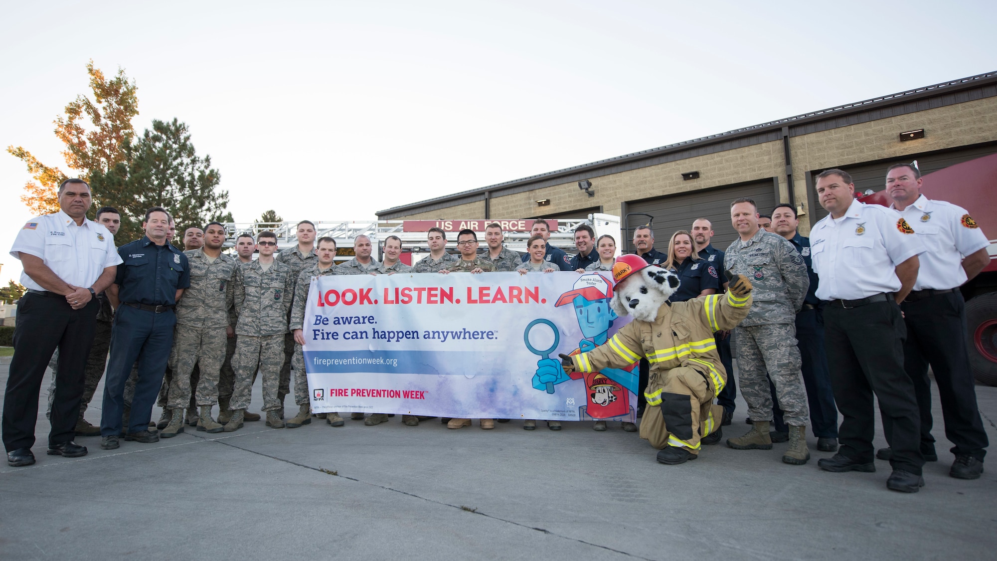 Firefighters from the 92nd Civil Engineering Squadron pose with Sparky the fire dog for the upcoming national Fire Prevention Week at Fairchild Air Force Base, Washington, Oct. 3, 2018. This year's Fire Prevention Week's campaign is "Look. Listen. Learn. Be aware. Fire can happen anywhere," which aims to educate the public about basic but essential ways to quickly and safely escape a home fire. (U.S. Air Force photo/Senior Airman Ryan Lackey)