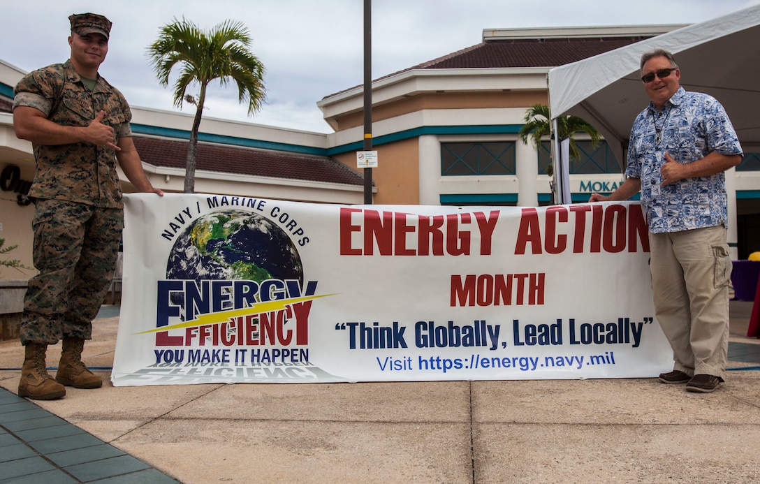 U.S. Marine Corps Cpl. Larry Hunter, an energy noncommissioned officer with Headquarters Battalion, Marine Corps Base Hawaii (MCBH) and Russell Koehler, the senior energy engineer for MCBH, pose for a photo during an Energy Awareness Month event, MCBH, Oct. 3, 2018. The event included alternative fueled vehicles and vendors with information on the importance of saving energy (U.S. Marine Corps photo by Cpl. Matthew Kirk)