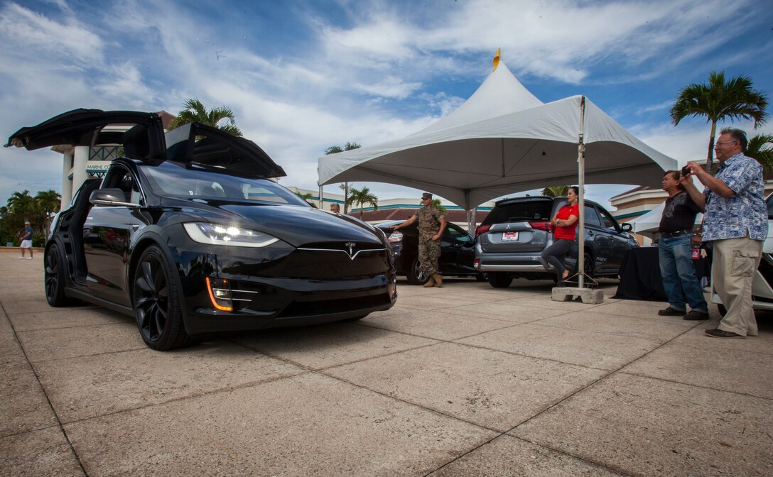 Spectators look at a Tesla Model X P100D on display during an Energy Awareness Month event, Marine Corps Base Hawaii, Oct. 3, 2018. The event included alternative fueled vehicles and vendors with information on the importance of saving energy (U.S. Marine Corps photo by Cpl. Matthew Kirk)