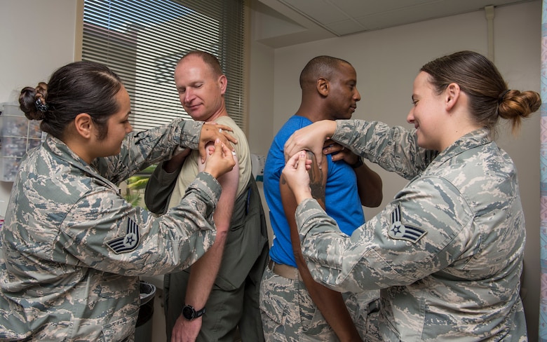 Col. Halsey Burks, 15th Wing commander, and Chief Master Sgt. Michael Cole, 15th WG command chief, receive their seasonal influenza vaccine at the 15th Medical Group Clinic, Joint Base Pearl Harbor-Hickam, Hawaii, Oct. 5, 2018. The vaccine helps prevent the virus from infecting a host and can reduce the severity of the flu. The Centers for Centers for Disease Control and Prevention recommends everyone receive a flu shot before flu season starts in November because it can take up to two weeks for the body to develop the antibodies to the virus. (U.S. Air Force photo by Tech. Sgt. Heather Redman)