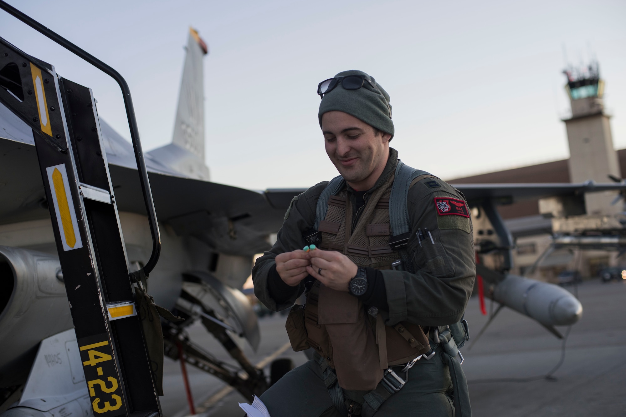 U.S. Air Force Capt. Mark Onorato, the 13th Fighter Squadron activity security manager, inspects his ear protection before climbing into an F-16 Fighting Falcon during Exercise Red Flag-Alaska 19-1, at Eielson Air Force Base, Alaska, Oct. 6, 2018. RF-A 19-1, held Oct. 4 to 19, is slated to train more than 1,000 personnel and 60 aircraft in a simulated air combat environment optimizing personnel's abilities and honing acquired skill sets. (U.S. Air Force photo by Airman 1st Class Collette Brooks)