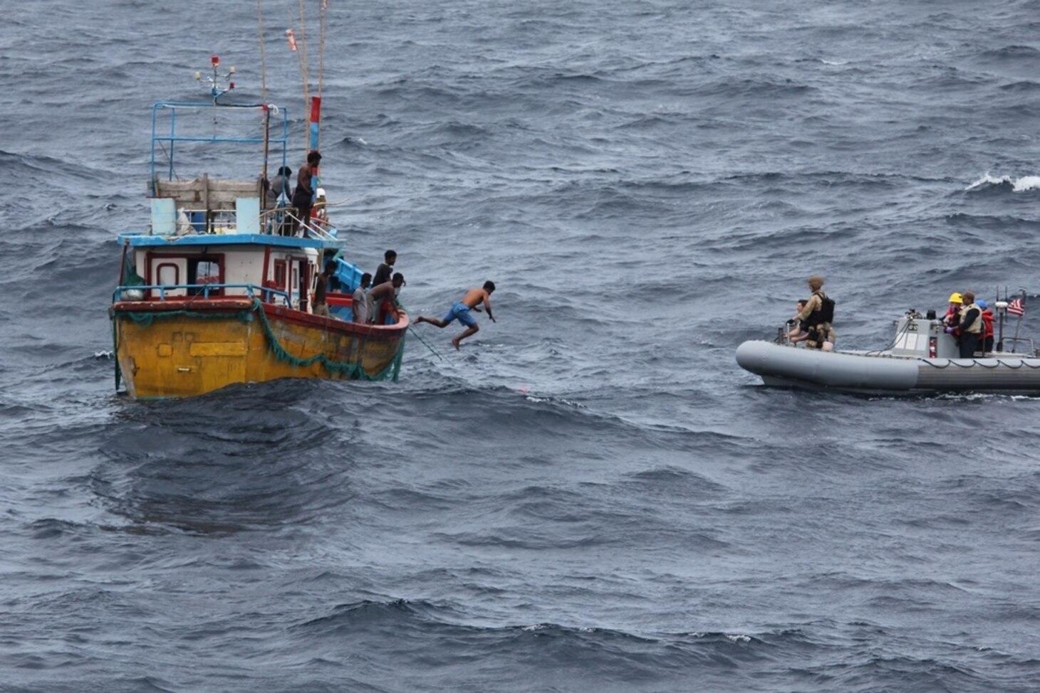 INDIAN OCEAN (Oct. 7, 2018) A Sri Lankan fisherman jumps and swims to a rigid-hull inflatable boat (RHIB) from the Arleigh Burke-class guided missile destroyer USS Decatur (DDG 73) after the ship stopped to render assistance to a stranded fishing vessel. After providing food and water, Decatur contacted the Sri Lankan authorities who came and towed the stranded vessel back to port. Decatur is forward deployed to the U.S. 7th Fleet area of operations in support of security and stability in the Indo-Pacific region.