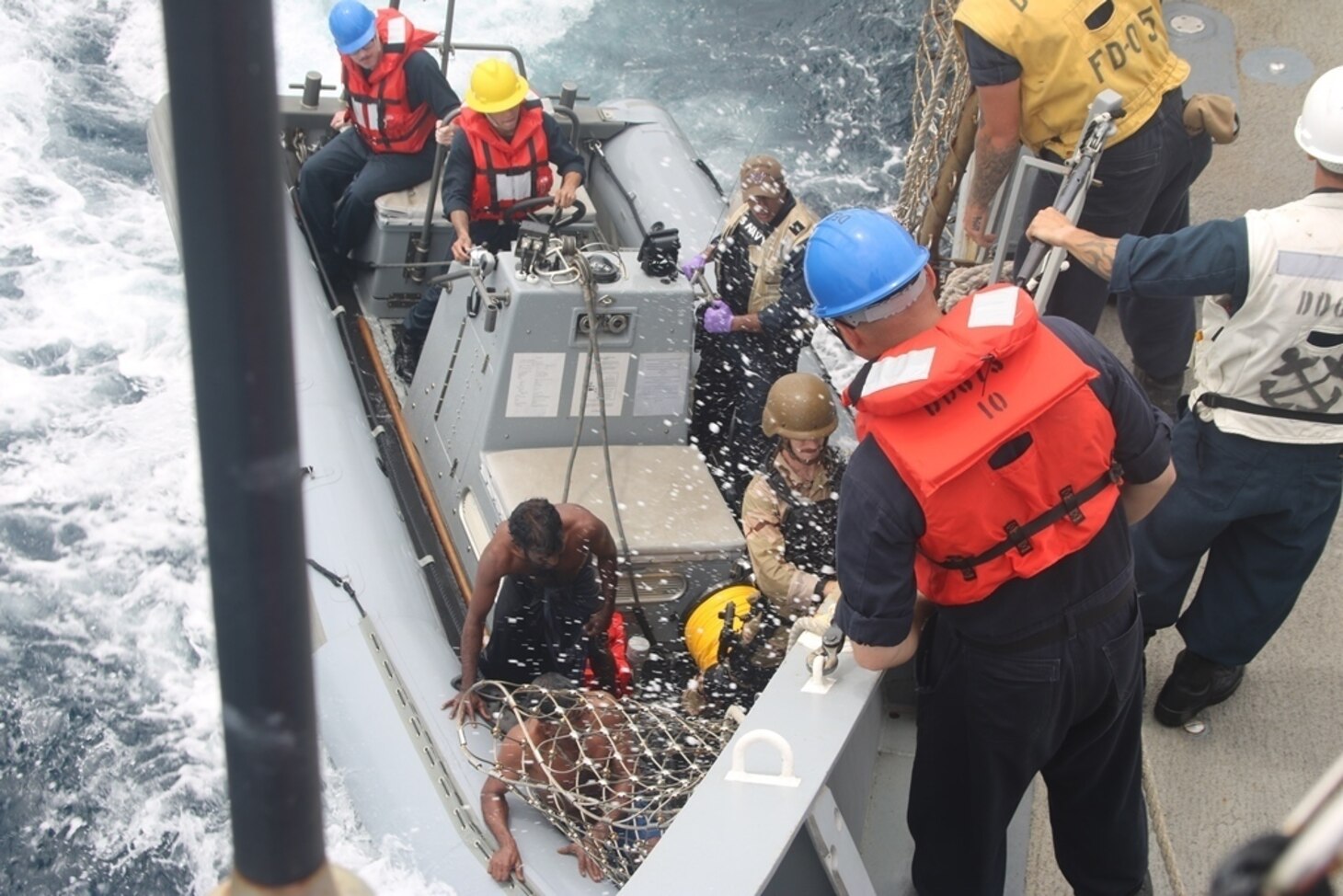 INDIAN OCEAN (Oct. 7, 2018) Sailors bring Sri Lankan fisherman aboard the Arleigh Burke-class guided missile destroyer USS Decatur (DDG 73) using a rigid-hull inflatable boat (RHIB) after the ship stopped to render assistance to a stranded fishing vessel. After providing food and water, Decatur contacted the Sri Lankan authorities who came and towed the stranded vessel back to port.  Decatur is forward deployed to the U.S. 7th Fleet area of operations in support of security and stability in the Indo-Pacific region.