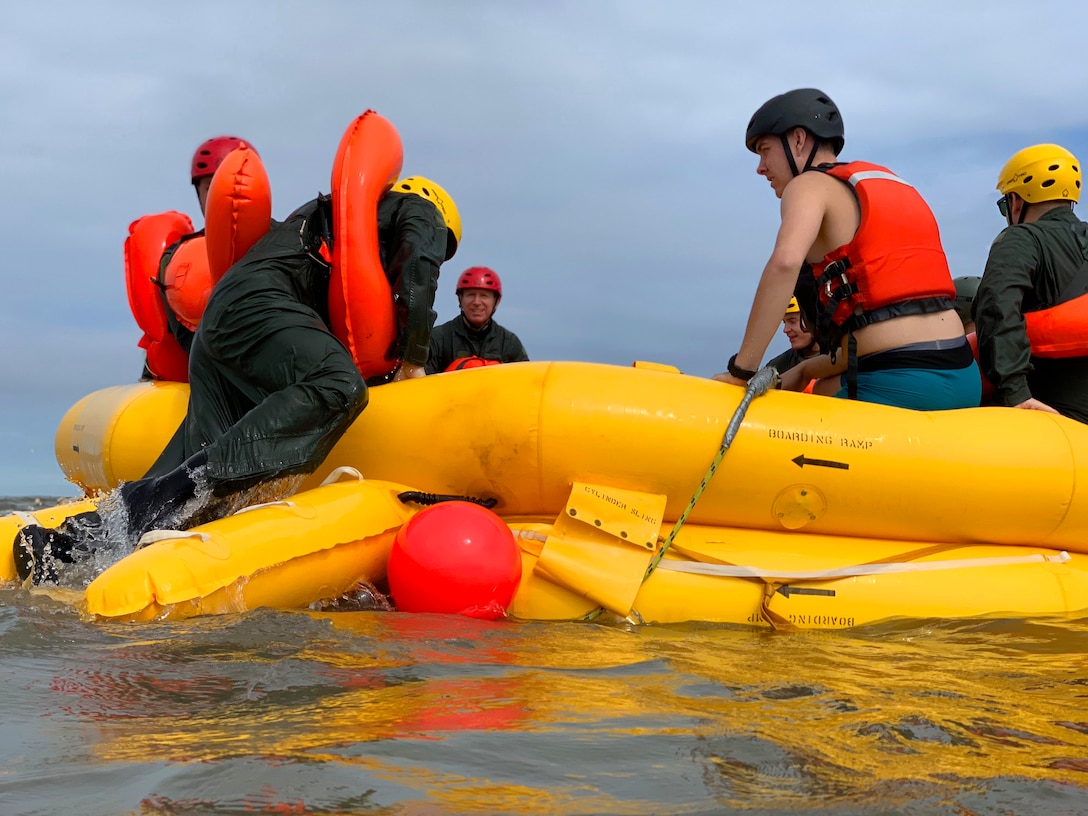 Airmen climb into a raft and await the arrival of a Coast Guard rescue team during water survival training Sept. 27, 2018, in the Atlantic Ocean off the coast of Bowers Beach, Del. The Air Force and Coast Guard work in tandem to create the most beneficial training environment for the Airmen.