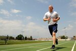Staff Sgt. Justin Norton, a 302nd Airlift Wing Public Affairs photojournalist, runs laps around the track Aug. 16 at Peterson Air Force Base, Colorado. Norton failed a fitness test in 2014 and has strived for top physical fitness ever since.